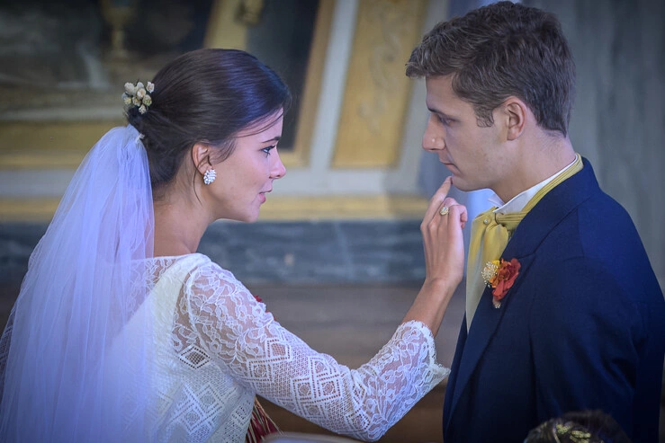 La mariée pointe délicatement le menton du marié pendant la cérémonie, moment intime et naturel
