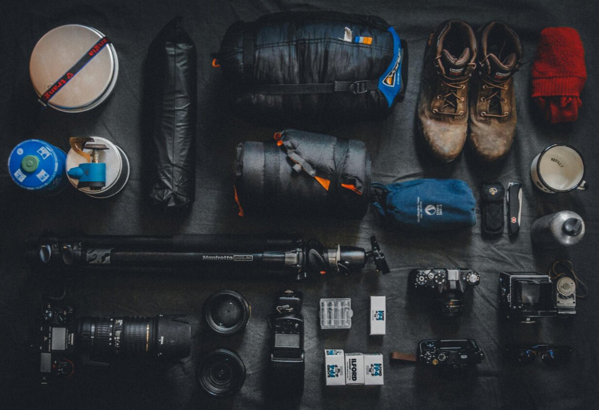 Matériel de photographe et équipement de reportage disposés à plat avec appareils photo, objectifs et accessoires